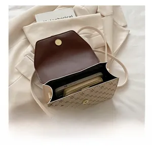 Detail view of the open crossbody bag showing space for a wallet and smartphone