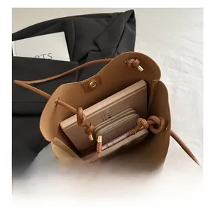 Vista interior del bolso de cuero marrón que muestra gran capacidad para libros y billetera