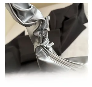 Detailed macro view of silver pleated handle with reinforced stitching and sleek zipper