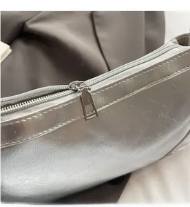 Detailaufnahme des glatten silbernen Metallreißverschlusses und des Leders der Tasche