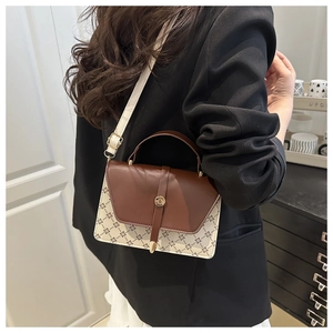 Detail of a chic crossbody bag featuring brown leather flap and monogram canvas patterns