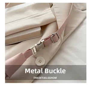 Détail macro de la bandoulière en cuir rose avec boucle et curseur en métal argenté