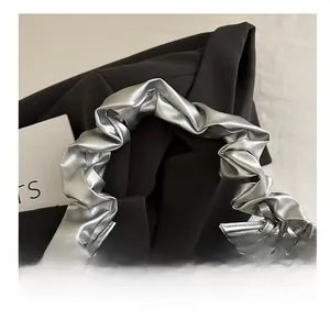 Close-up of metallic silver ruffled cloud bag showing detailed scrunchie handle texture