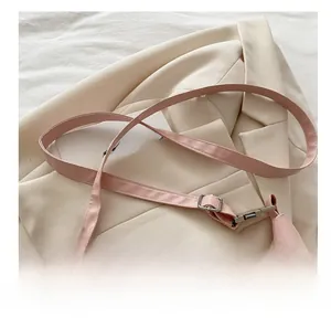 Détail de la bandoulière réglable en PU rose avec boucle en métal argenté sur tissu