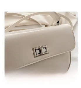 Détail du sac à main en similicuir crème avec fermoir rotatif en métal argenté brillant