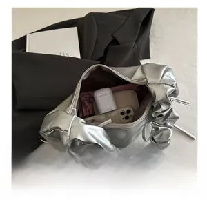 Detail showing inner capacity of the silver pleated cloud bag with metallic finish