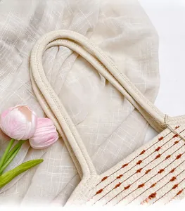 Detail of woven cotton rope handbag handle with beige and brown decorative stitching