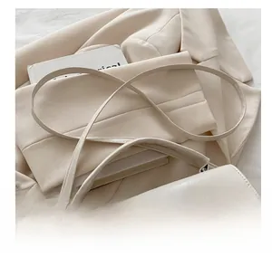 Détail du sac à bandoulière crème avec fermoir rotatif argenté et cuir grainé