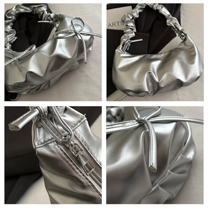 Detail of silver metallic underarm bag with pleated handle and bow knot accents