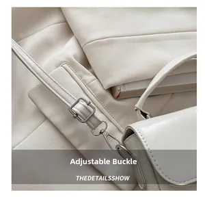 Détail de la boucle métallique réglable sur le sac à bandoulière en cuir crème