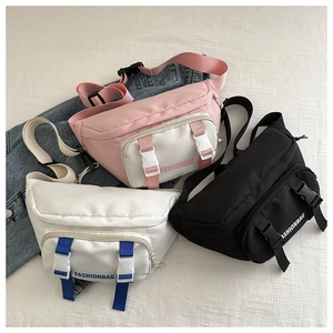 Close-up of three utility crossbody bags in pink, white, and black with plastic buckles
