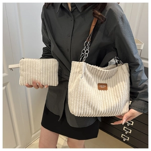 Detail of off-white corduroy tote set with brown leather chain strap and logo patch