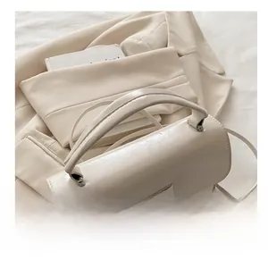 Gros plan d'un sac à main crème en cuir texturé avec fermoir rotatif en métal