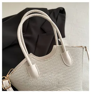 Close-up of woven bucket bag featuring wavy leather trim and golden metal hardware details