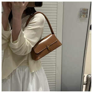 Détail du sac rétro marron avec fermoir doré en métal et texture en similicuir lisse