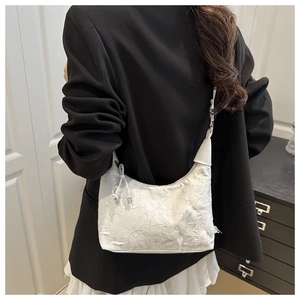 Détails de texture du sac à bandoulière en dentelle blanche avec broderies et plis