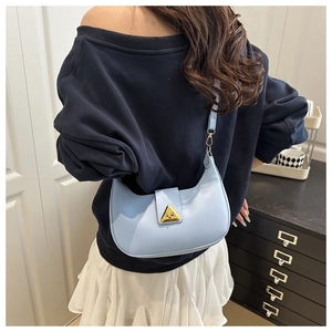 Vista posteriore della modella con borsa a spalla azzurra e fibbia dorata lucida
