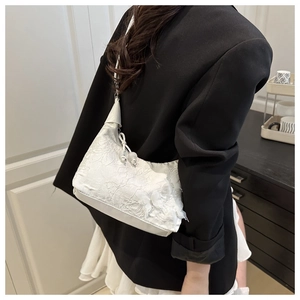 Détail de la broderie florale en dentelle blanche sur le sac hobo de grande capacité