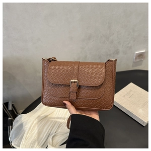 Détail de la texture crocodile marron vintage sur un sac baguette bandoulière