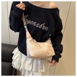 Détail du sac seau en dentelle rose clair avec des fleurs 3D et des papillons brodés