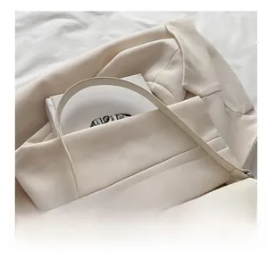 Détail d'un sac à bandoulière blanc crème minimaliste en cuir synthétique brillant à rabat
