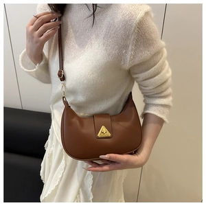 Dettaglio di una borsa hobo marrone con fibbia metallica a triangolo dorata e tracolla
