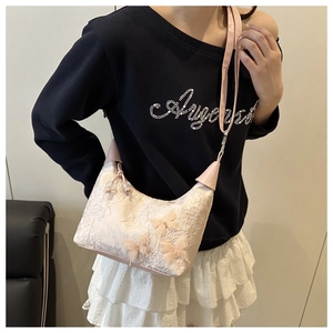 Détail du sac à bandoulière en dentelle florale avec papillons 3D et sangle en cuir
