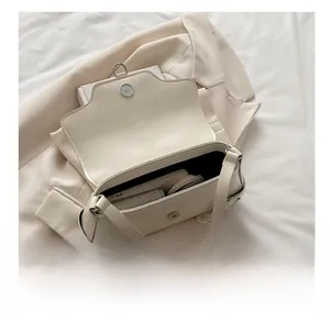 Vue détaillée du rangement intérieur du sac à bandoulière en similicuir crème sur blazer