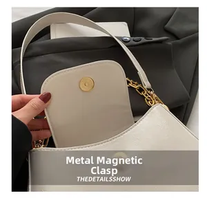 Detail showing high-quality gold magnetic snap closure and textured PU leather on cream bag