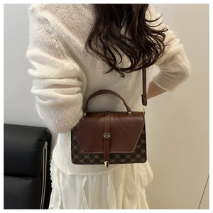 Detail of vintage brown shoulder bag with monogram texture and adjustable strap
