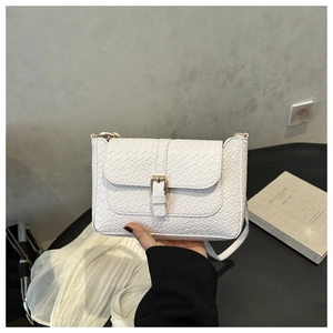 Détail du sac à bandoulière blanc à motif crocodile avec boucle en métal doré