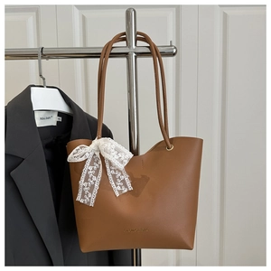 Sac fourre-tout marron avec nœud en dentelle blanche et texte Fashion Bag sur fond de porte