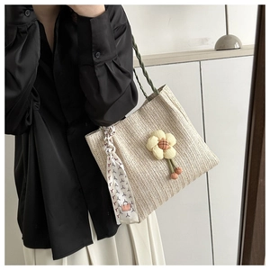 Vue détaillée du sac cabas tissé avec fleurs décoratives et détail de foulard en soie