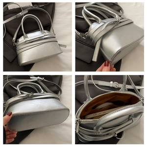 Detailed interior of silver shell bag showing zip pocket and adjustable shoulder strap