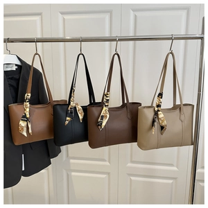 Detail of four colorful leather tote bags with decorative patterned scarves on handles