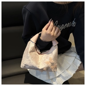 Détail d'un sac en dentelle rose clair avec papillons en soie 3D et broderies