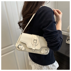 Détail du sac à bandoulière baguette blanc crème sur modèle pour un look rétro et tendance