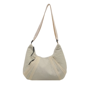 Minimalist cream crescent tote bag with pleated nylon fabric and adjustable strap