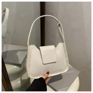 Détail de la texture tressée blanche et de l'anse d'un sac sous les aisselles de style français