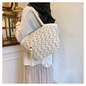 Detailed view of woven cotton tote bag with decorative wooden beads and fringe tassel