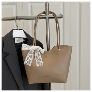 Détail du sac cabas kaki avec nœud en dentelle et texte Fashion Bag sur costume