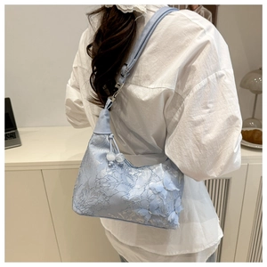 Détail du sac bleu clair avec broderie florale en dentelle et papillons 3D perlés