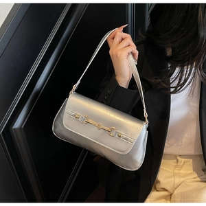 Close-up of silver leather handbag with golden horsebit buckle hardware and sleek strap