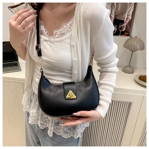 Dettaglio della borsa hobo minimalista in pelle nera con chiusura a triangolo dorata