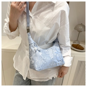 Gros plan sac bandoulière jacquard bleu clair avec broderie papillon 3D détaillée
