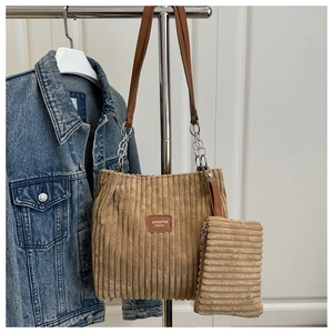 Detail of khaki corduroy tote with chain strap and matching mini pouch on a hanger