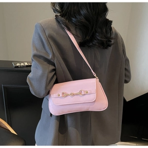 Pink shoulder bag detail showing faux leather texture and golden metal buckle decoration
