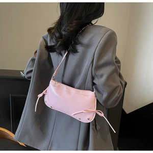 Schultertasche aus rosa Lackleder mit Schleifendetails und silbernen Nieten im Detail