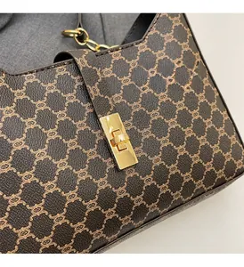 Dettaglio borsa a spalla vintage con monogramma e chiusura a girello in oro lucido