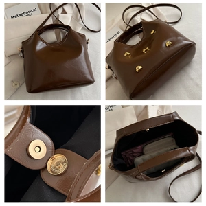 Macro view of dark brown oil-wax leather texture and golden animal stud on the handbag